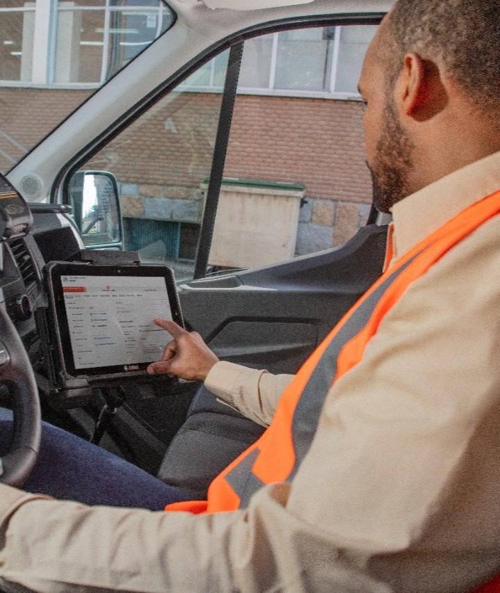 Field service technician in van touching the tablet screen.