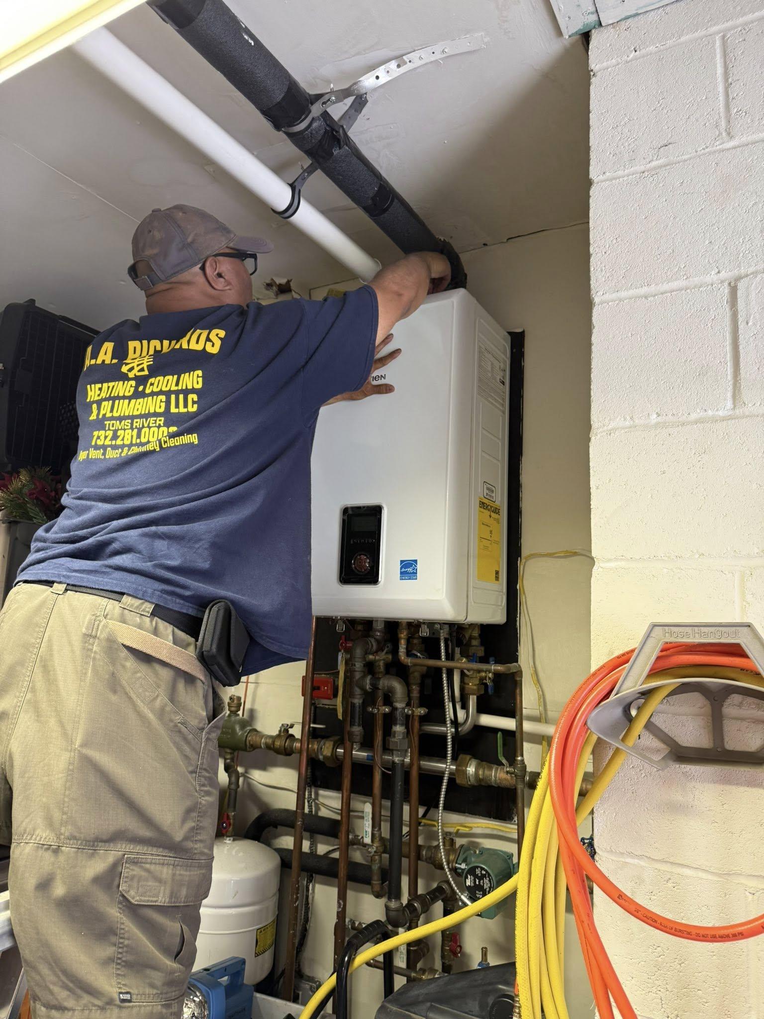 HVAC technician servicing a wall-mounted boiler, adjusting the exhaust pipe in a basement utility room.